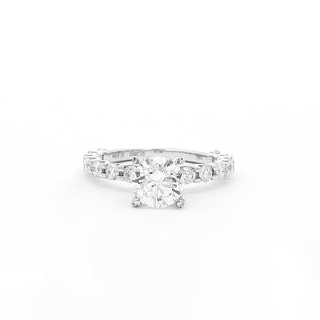 This 18K White Gold ring features a classic round-cut centre, accentuated by round sidestones along the band. This timeless design offers the perfect blend of elegance and sophistication, making it the perfect choice for an engagement ring!