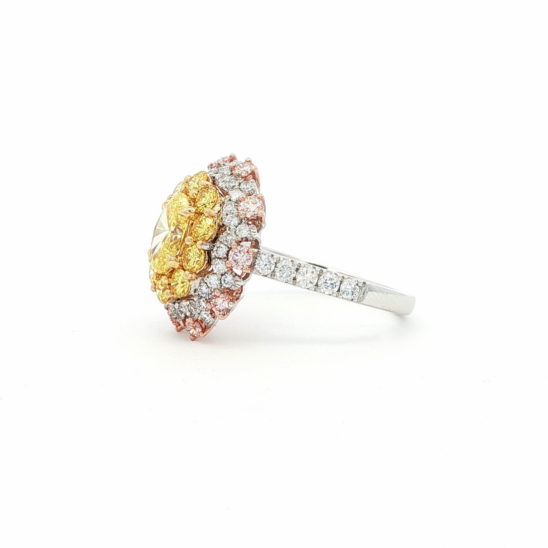 This 18KT Yellow Gold ring showcases a vibrant center of brilliant yellow diamonds, elegantly encircled by a halo of pink and white diamonds. The bold contrasts of colors create a captivating play of light, making it a true statement piece for any occasion.