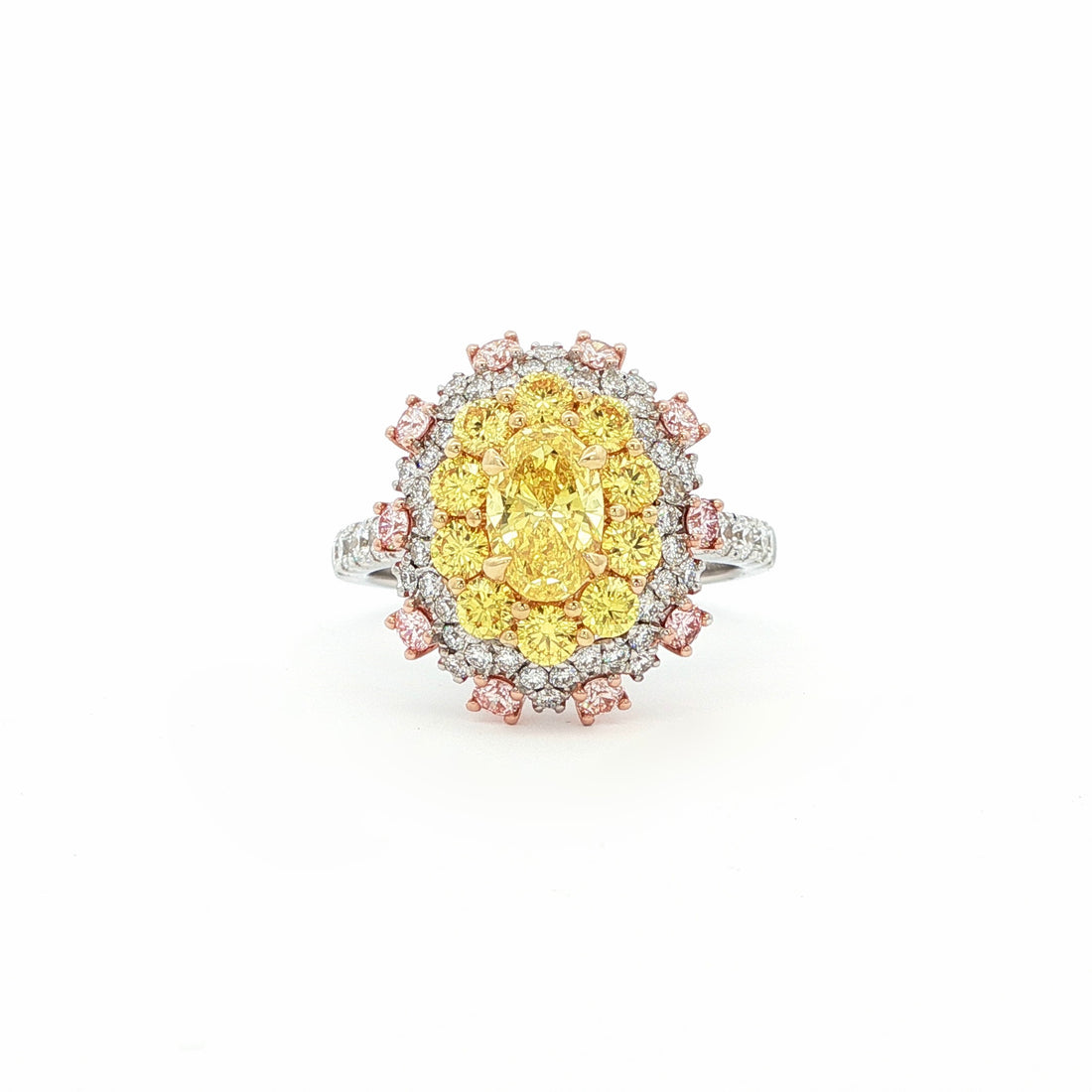 This 18KT Yellow Gold ring showcases a vibrant center of brilliant yellow diamonds, elegantly encircled by a halo of pink and white diamonds. The bold contrasts of colors create a captivating play of light, making it a true statement piece for any occasion.