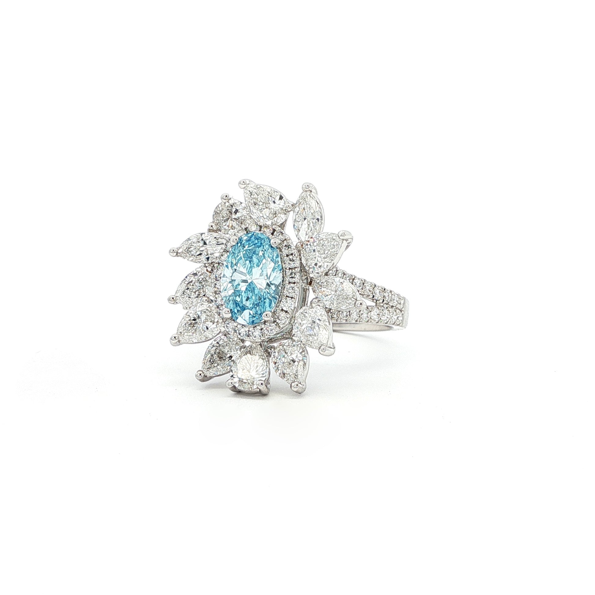 This 18K White Gold Ring showcases an exquisite floral design with a captivating oval-cut blue diamond centre, framed with white diamond "petals". A timeless embodiment of luxury and sophistication, perfect for making a statement!
