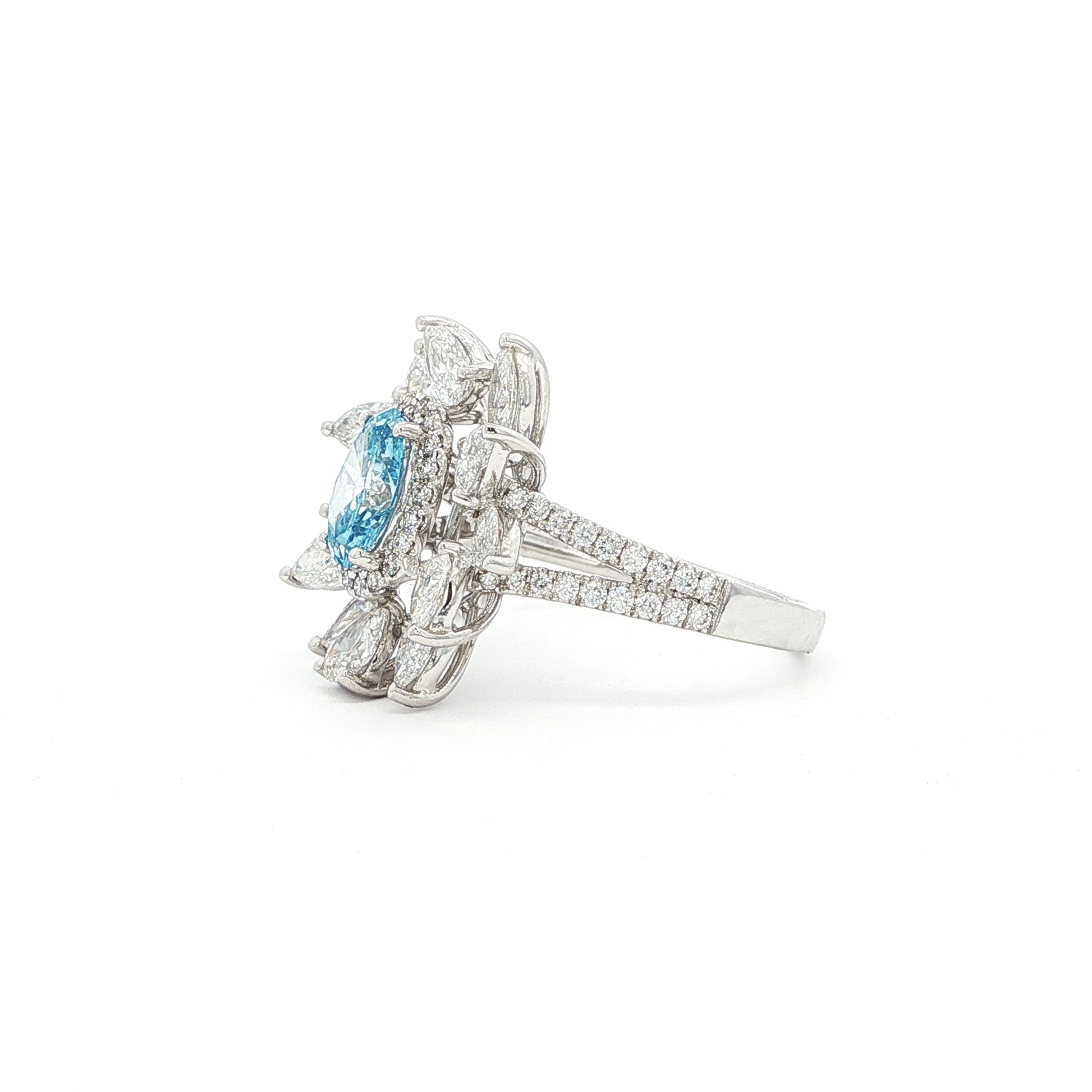 This 18K White Gold Ring showcases an exquisite floral design with a captivating oval-cut blue diamond centre, framed with white diamond "petals". A timeless embodiment of luxury and sophistication, perfect for making a statement!