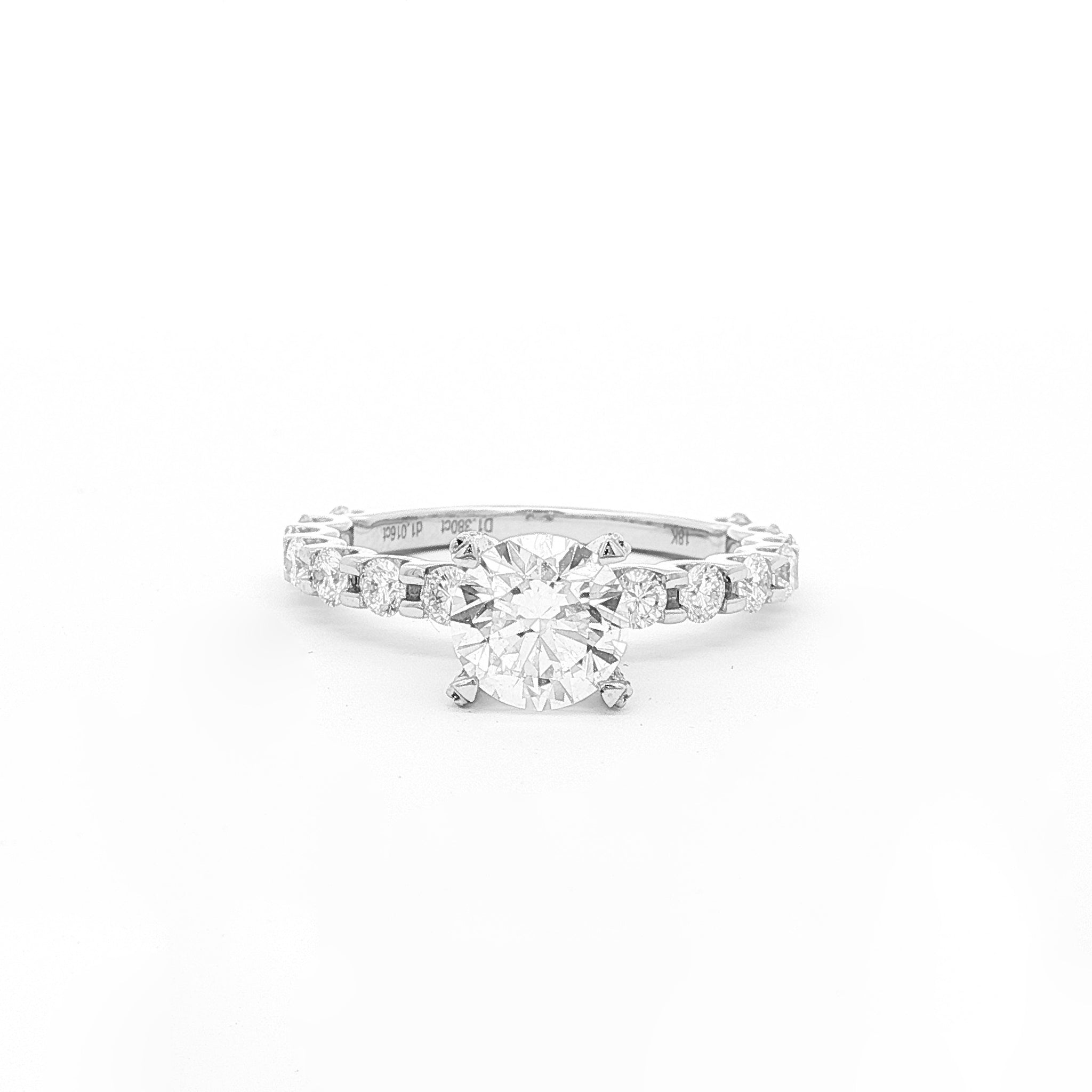 This 18K White Gold ring features a classic round-cut centre, accentuated by round sidestones along the band. This timeless design offers the perfect blend of elegance and sophistication, making it the perfect choice for an engagement ring!