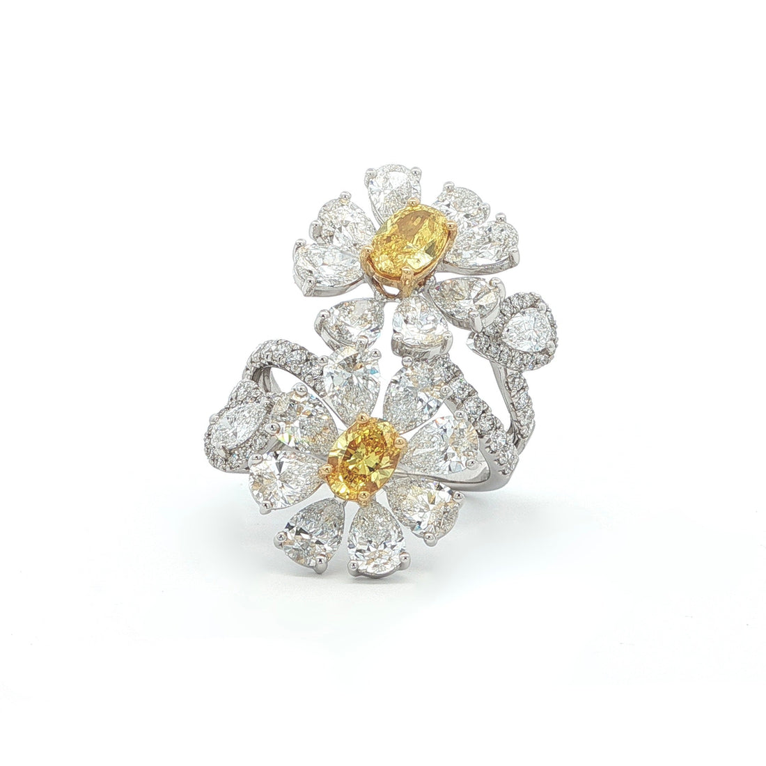 This 18K White Gold ring features a floral-inspired design with two oval-cut fancy yellow diamonds, expertly cut in a brilliant style. These radiant gems are accented by white diamond "petals"; creating a stunning contrast and adding to the ring's overall charm and opulence. A true statement piece for any special occasion!