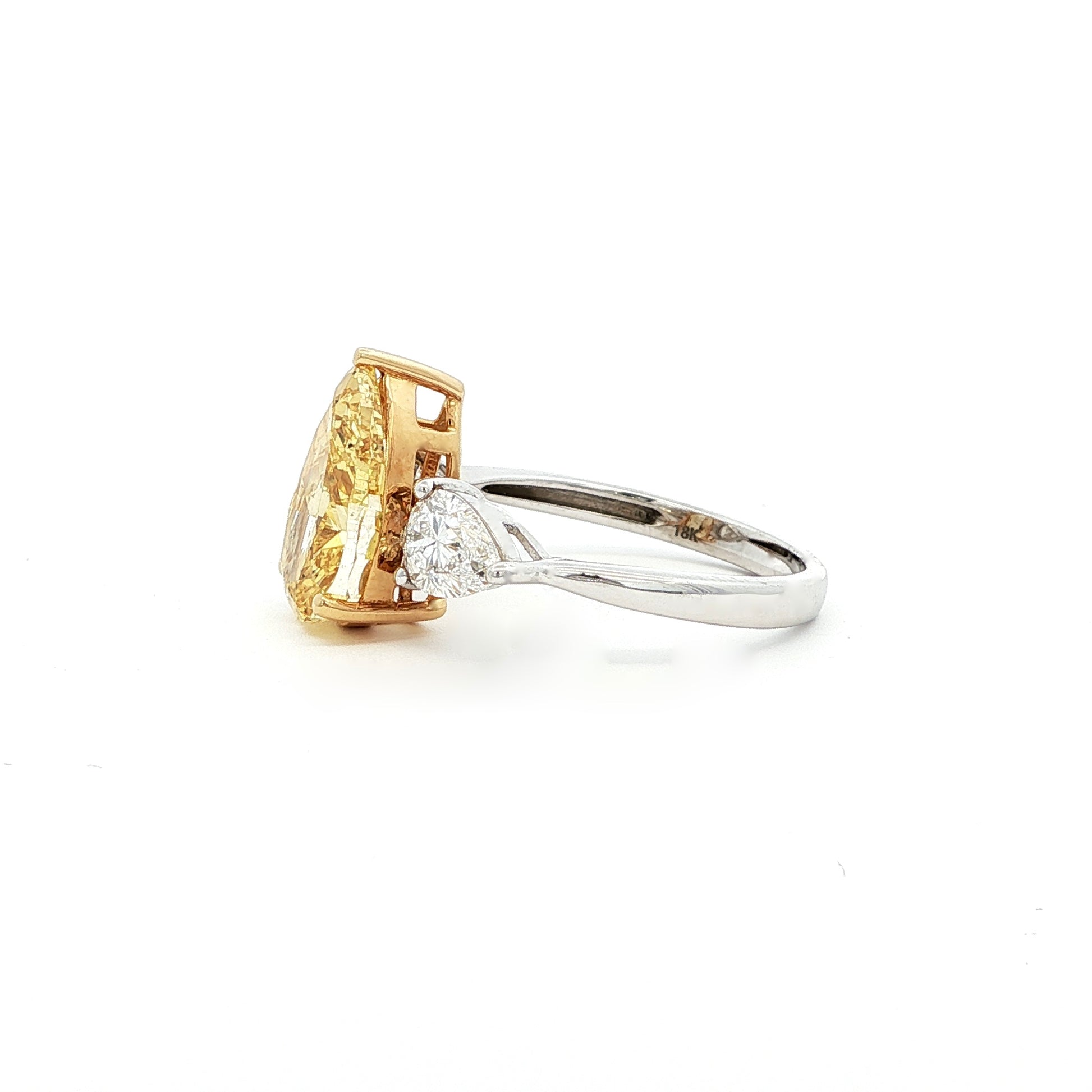 This 18K White Gold ring features a fancy yellow pear-cut diamond at its centre, framed by two pear-cut side stones. Perfect for special occasions or as a statement piece in your everyday jewelry collection!