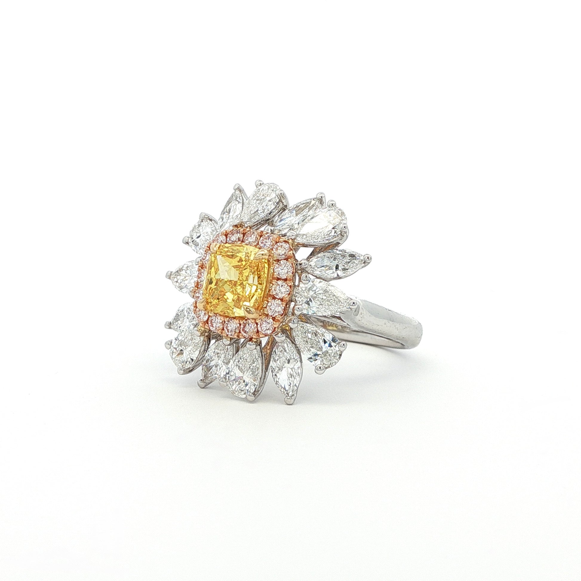 The sunflower-inspired Lumine ring is crafted in 18K tri-color gold (White, Yellow, and Rose Gold). At the centre is a fancy yellow cushion-cut diamond set in Yellow Gold. Surrounding it is a halo of pink diamonds set in Rose Gold. Completing the bloom are "petals" of white diamond set in White Gold. The result is a bold and captivating dual-tone statement piece, perfect for adding a touch of glamour to any evening look.