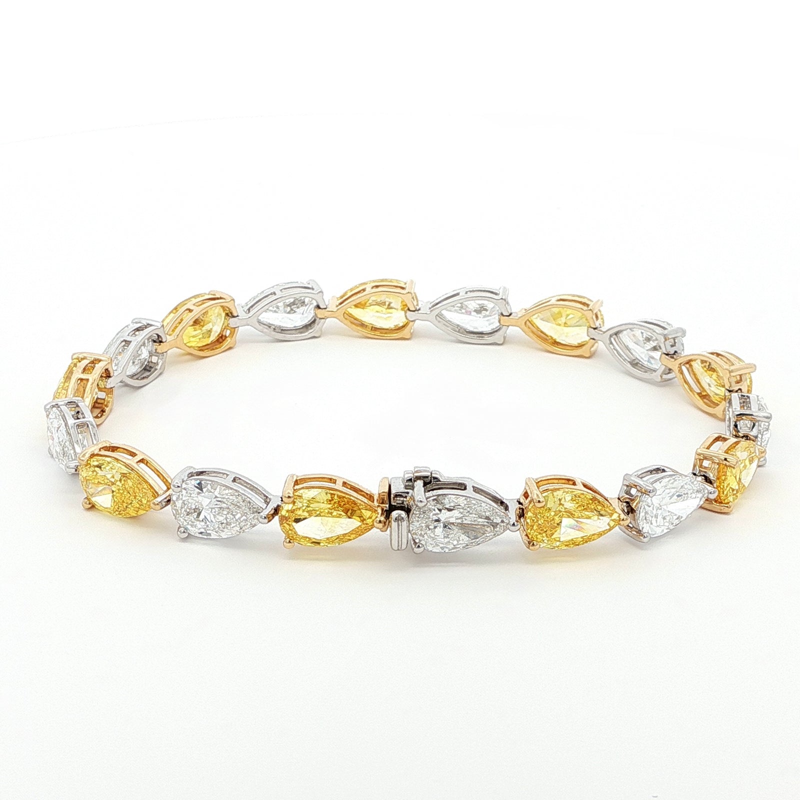 18K White and Yellow Gold Duo-Tone Pear-Cut Lab-Grown Diamond Bracelet A bold, duo-tone bracelet that showcases Pear-cut diamonds in an alternating pattern of white and yellow stones. Each diamond is securely held in place by a refined three-prong design, with white diamonds set in white gold and yellow stones in yellow gold. Crafted in a sophisticated combination of 18K White and Yellow Gold, this bracelet offers modern luxury for any occasion.
18K 白金同黃金雙色梨形切割實驗室種植鑽石手鍊

大膽嘅雙色手鍊，以白色同黃色石頭嘅交替圖案展示梨形切割鑽石。每顆鑽石都係