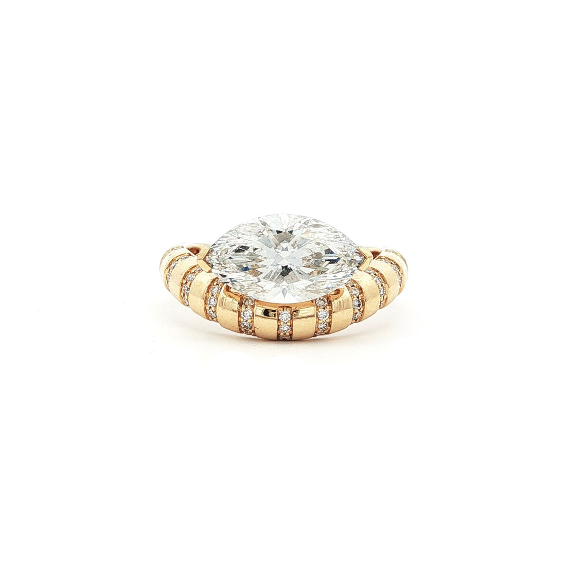 This 18K Yellow Gold ring showcases a Marquise centre stone set on a bold band, decorated with sparkling diamonds. Its exquisite craftsmanship and sophisticated design make it the perfect statement piece for any look!