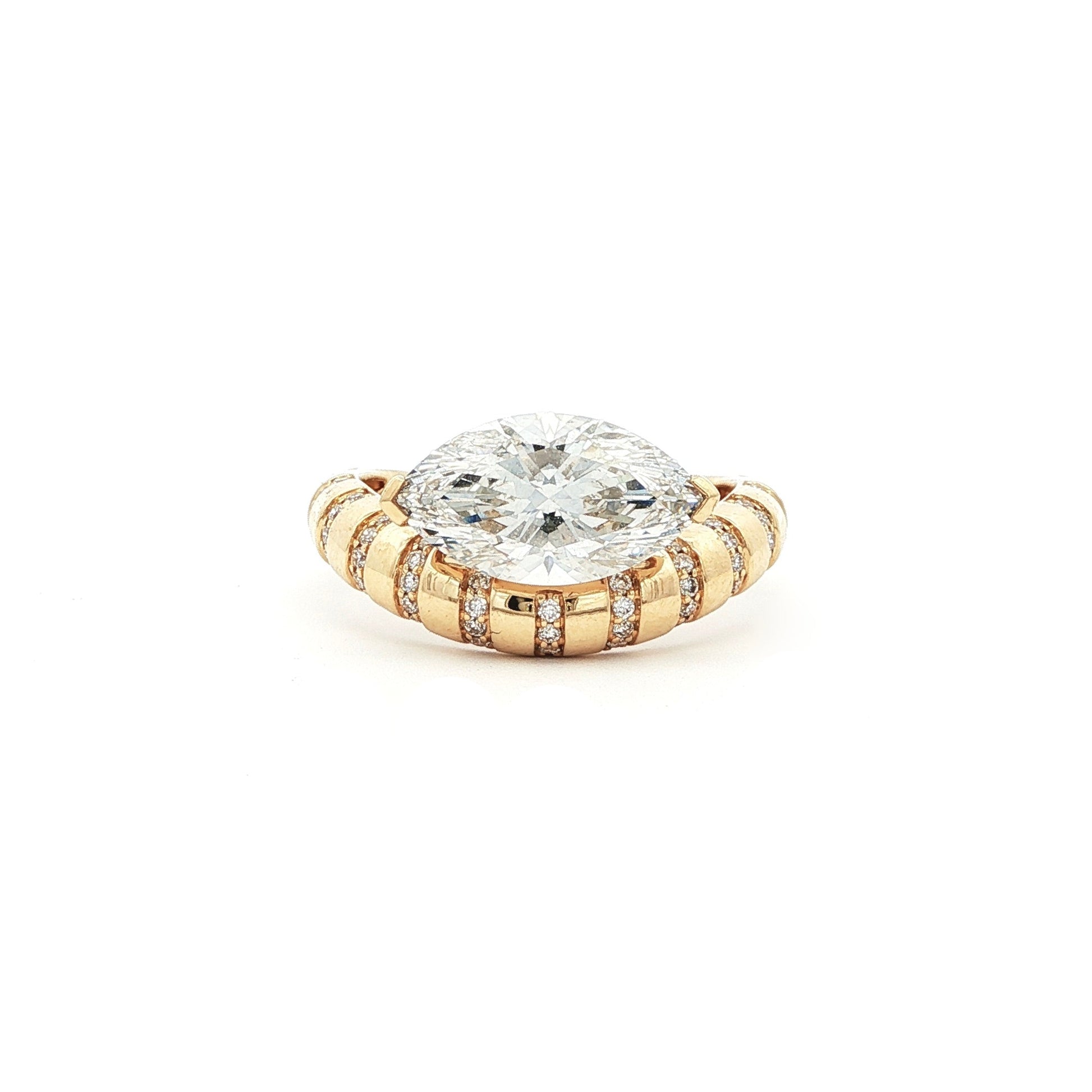 This 18K Yellow Gold ring showcases a Marquise centre stone set on a bold band, decorated with sparkling diamonds. Its exquisite craftsmanship and sophisticated design make it the perfect statement piece for any look!