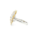 This 18K Yellow Gold ring exudes luxury, showcasing a yellow oval-cut diamond centre with a delicate floral-inspired halo adorned with white and yellow diamonds. The meticulous craftsmanship makes it a standout piece, perfect for adding a touch of glamor to your look!