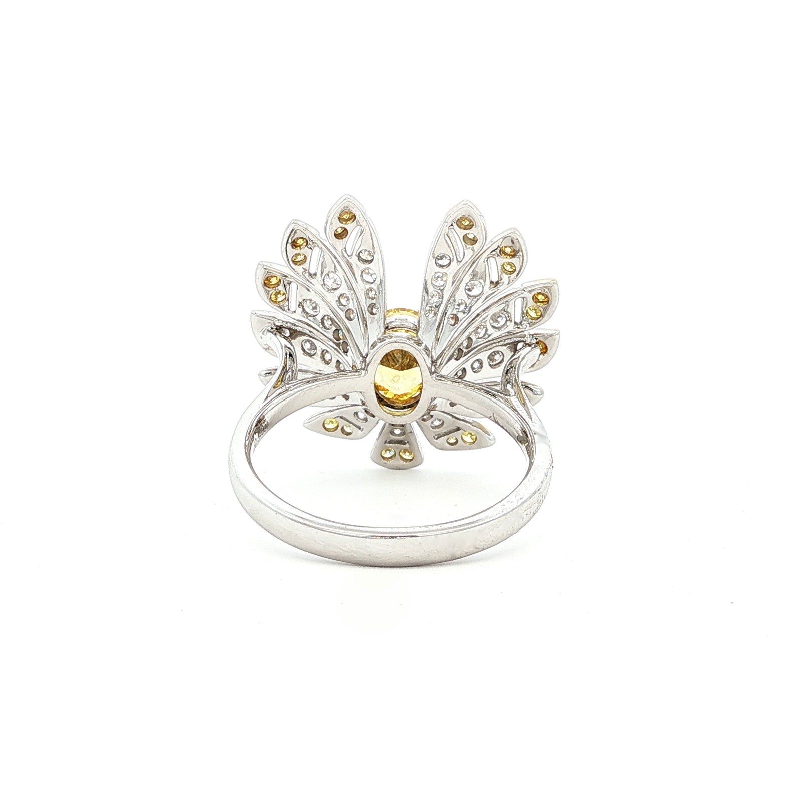 This 18K Yellow Gold ring exudes luxury, showcasing a yellow oval-cut diamond centre with a delicate floral-inspired halo adorned with white and yellow diamonds. The meticulous craftsmanship makes it a standout piece, perfect for adding a touch of glamor to your look!