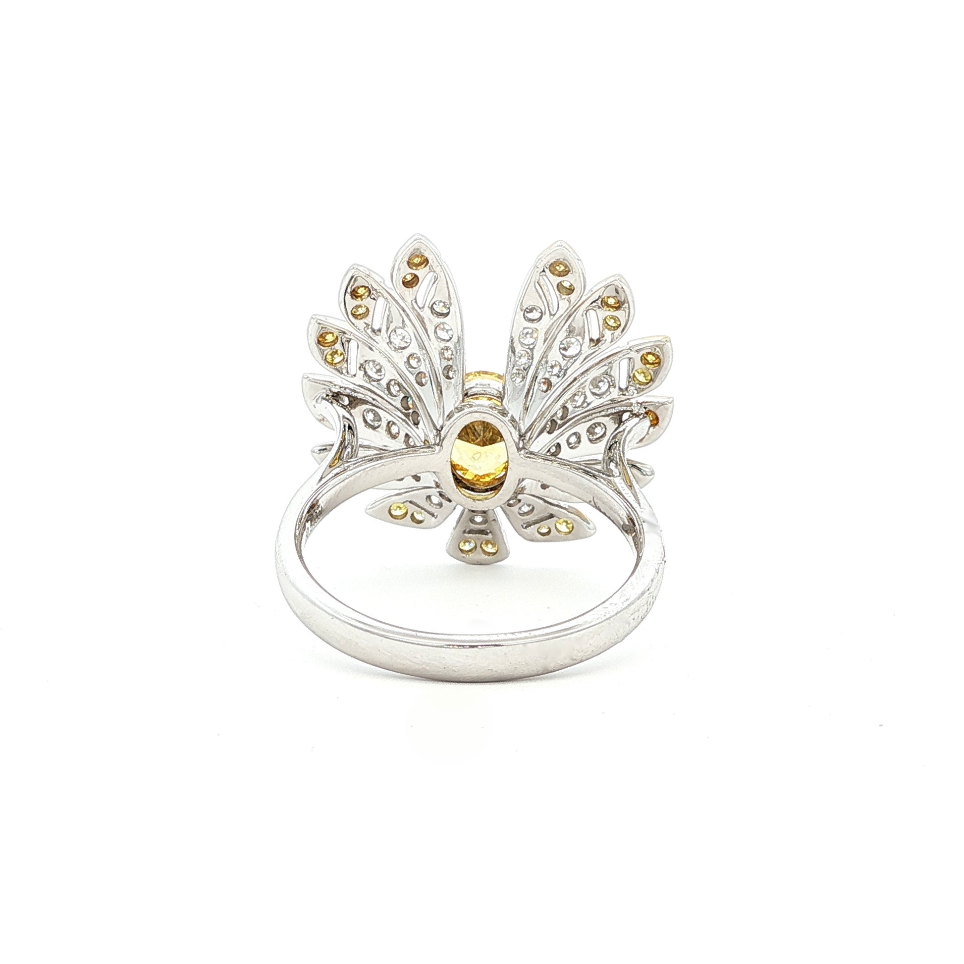 This 18K Yellow Gold ring exudes luxury, showcasing a yellow oval-cut diamond centre with a delicate floral-inspired halo adorned with white and yellow diamonds. The meticulous craftsmanship makes it a standout piece, perfect for adding a touch of glamor to your look!