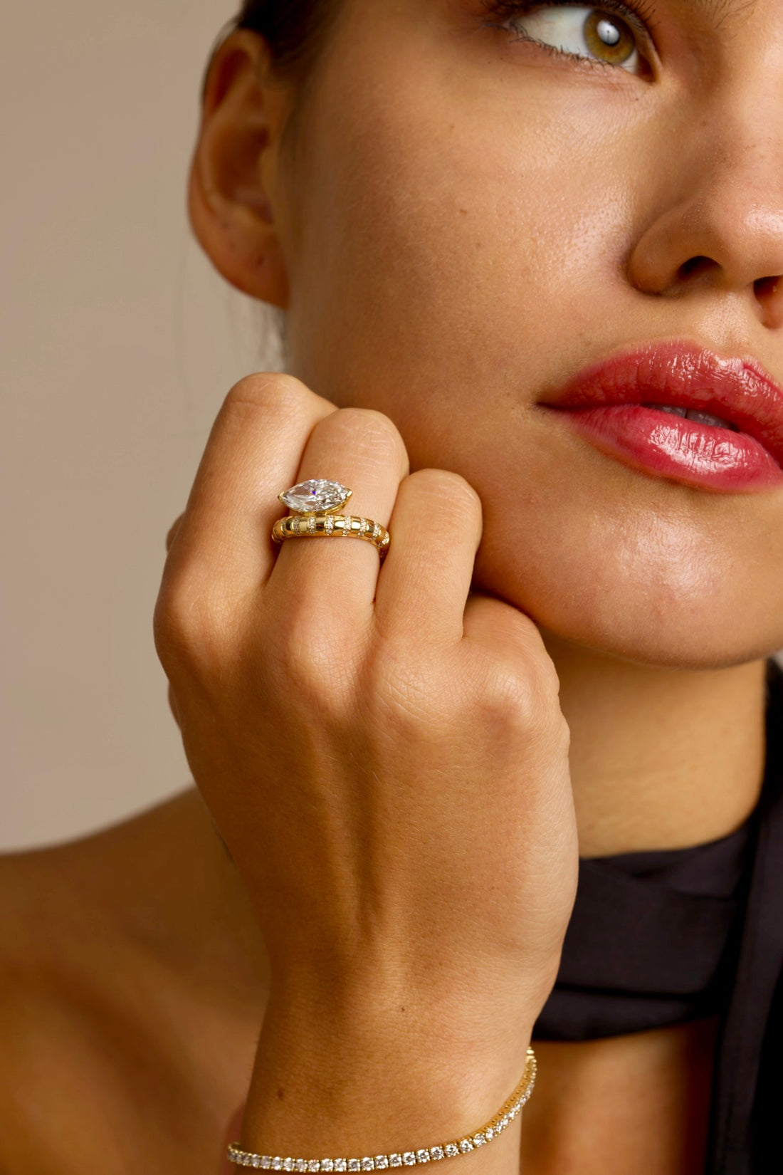 This 18K Yellow Gold ring showcases a Marquise centre stone set on a bold band, decorated with sparkling diamonds. Its exquisite craftsmanship and sophisticated design make it the perfect statement piece for any look!