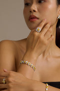 Woman wearing a floral bracelet and ring with a neutral background