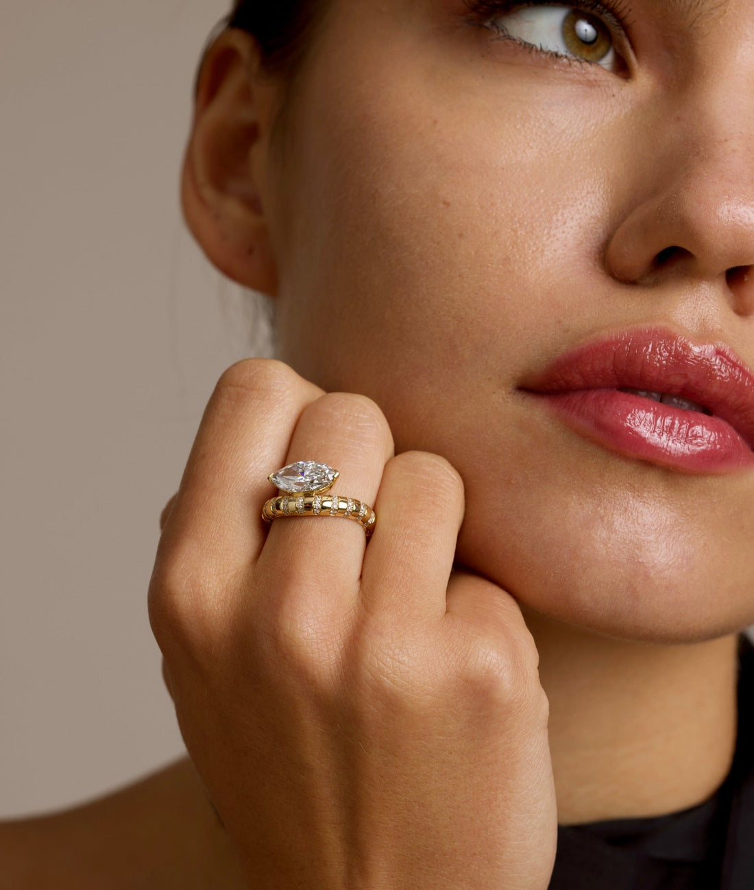 This 18K Yellow Gold ring showcases a Marquise centre stone set on a bold band, decorated with sparkling diamonds. Its exquisite craftsmanship and sophisticated design make it the perfect statement piece for any look!