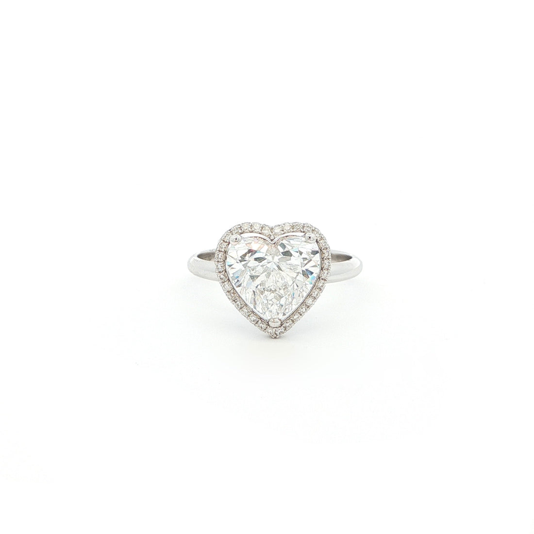 Crafted in 18K White Gold, this ring features a brilliant heart-shaped lab-grown diamond embraced by a glittering halo. Beneath the centre stone, a hidden halo adds an extra tier of light, the double-halo effect creates depth and radiance, making this ring a true statement of elegance.