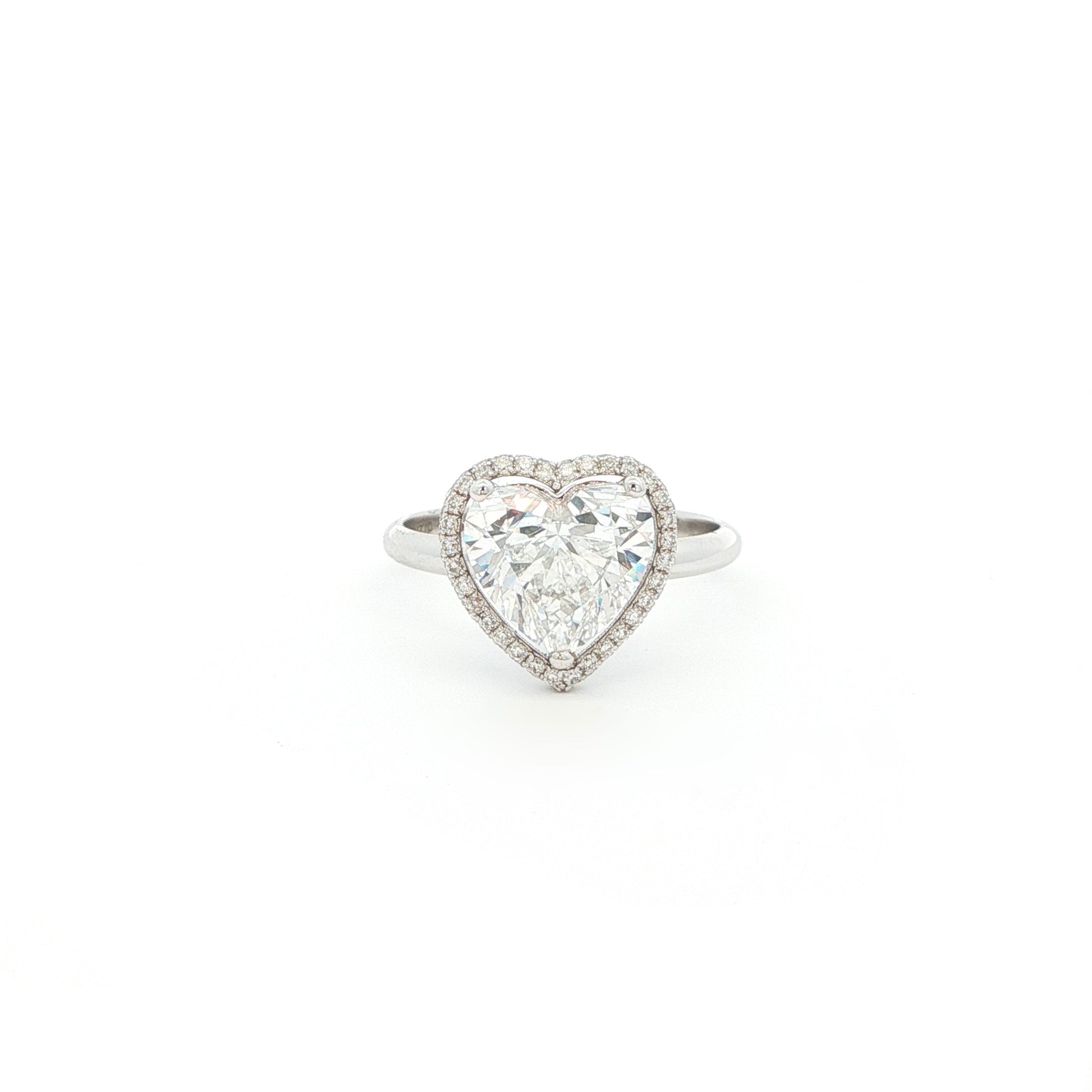 Crafted in 18K White Gold, this ring features a brilliant heart-shaped lab-grown diamond embraced by a glittering halo. Beneath the centre stone, a hidden halo adds an extra tier of light, the double-halo effect creates depth and radiance, making this ring a true statement of elegance.