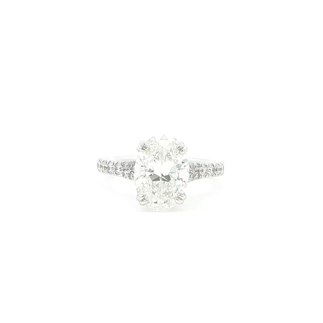 Oval cut lab grown diamond ring with pavé set accent band in 18k white gold. 