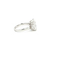 Three-stone ring featuring a lab-grown emerald cut center diamond with two emerald side stones, set in a classic design in 18k gold.