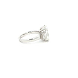 Three-stone ring featuring a lab-grown emerald cut center diamond with two emerald side stones, set in a classic design in 18k gold.