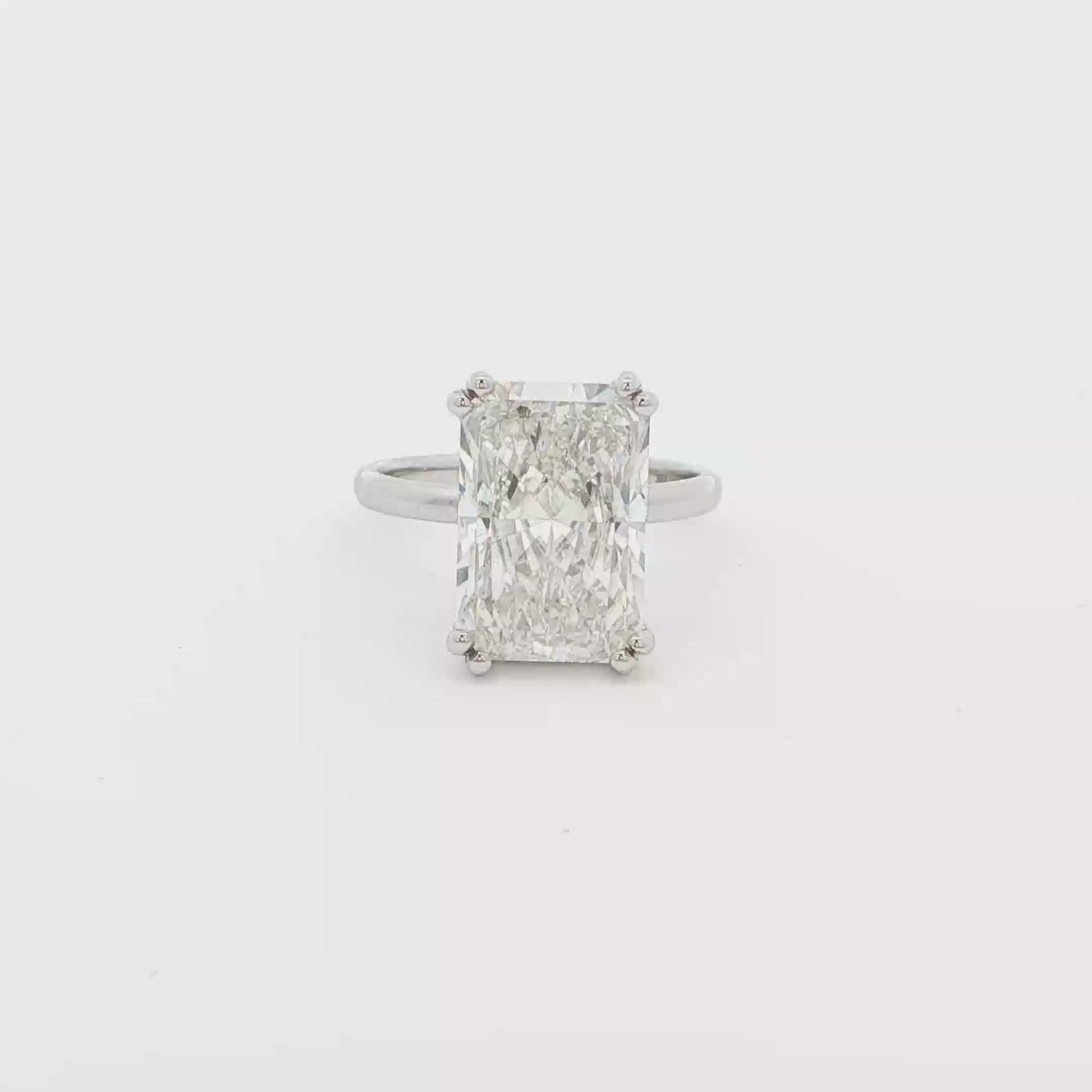 Radiant cut lab-grown diamond solitaire ring set in 18K white gold band, timeless engagement design.