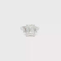 Three-stone ring featuring a lab-grown emerald cut center diamond with two emerald side stones, set in a classic design.